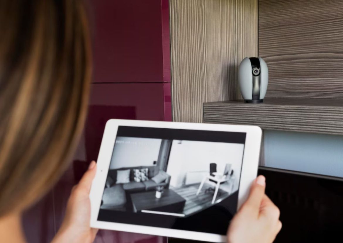 Surveillance discrète avec des gadgets avec caméras espion. Femme surveillant sa maison via une tablette connectée à des gadgets avec caméras espion.