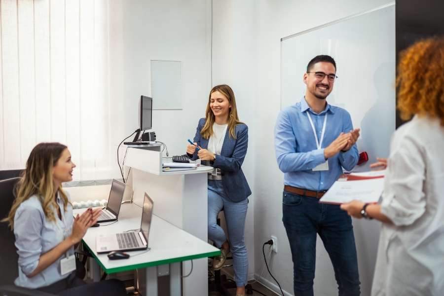 Réussite professionnelle grâce aux certifications en ligne reconnues. Groupe de collègues applaudissant après l’obtention de certifications en ligne reconnues.