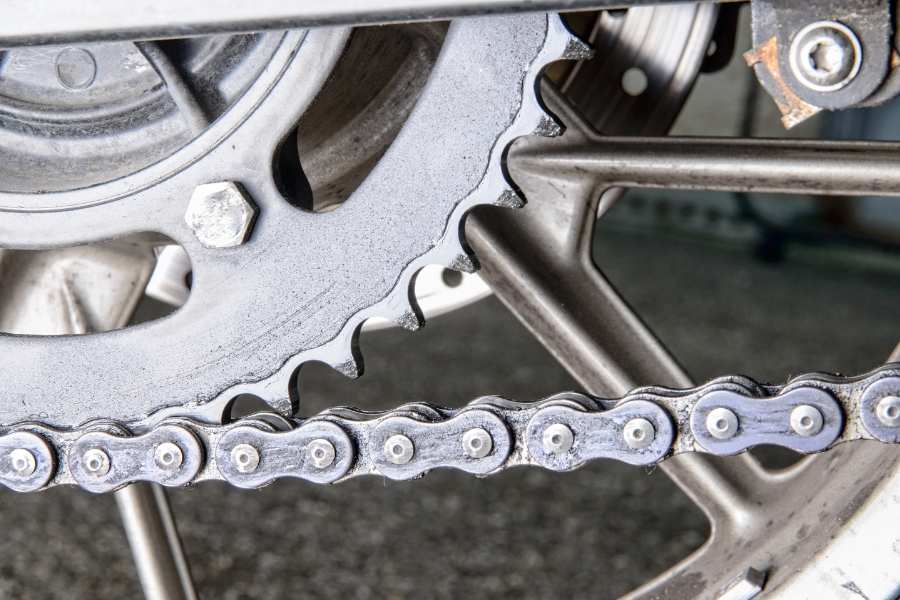 Pignon et chaîne de transmission de moto. Détail d’un pignon relié à une chaîne de transmission de moto.