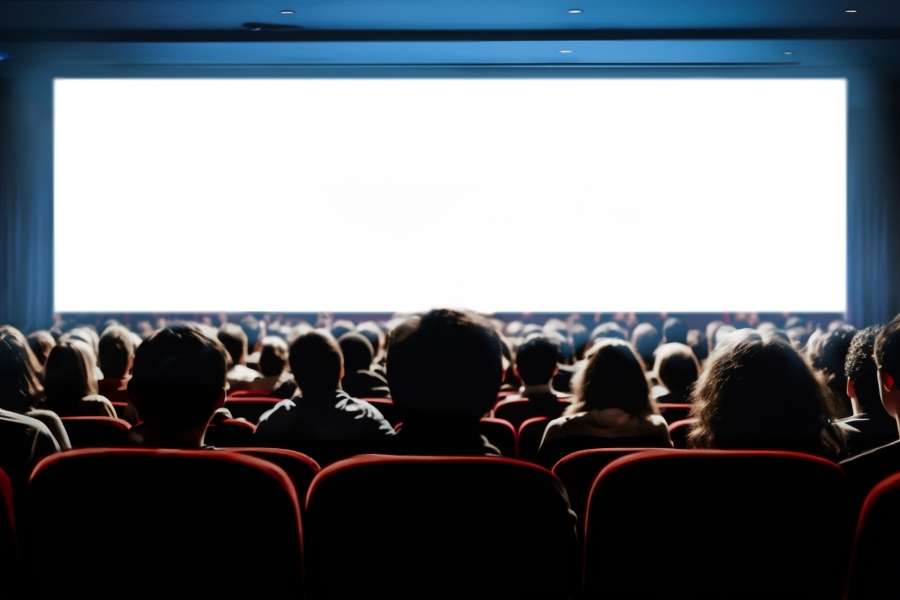 Expérience immersive dans un cinéma indépendant. Spectateurs captivés par un film projeté sur grand écran dans un cinéma indépendant.