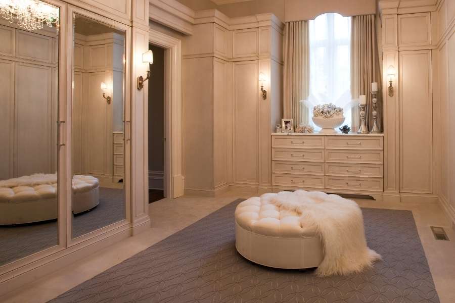 Dressing sur mesure élégant avec miroirs intégrés et assise centrale capitonnée.