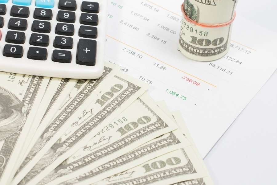Solutions financières pour financer sa formation. Calculatrice et billets de cent dollars illustrant les démarches pour financer sa formation.
