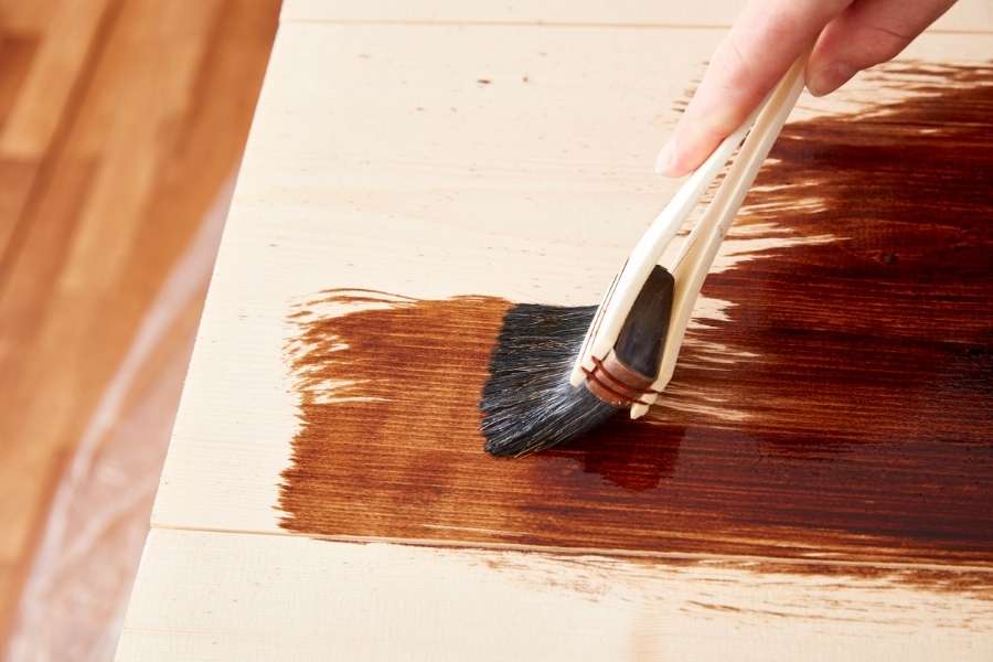 Finition huilée foncée sur bois clair. Application d’une huile teintée foncée sur une planche en bois clair pour une finition huilée.