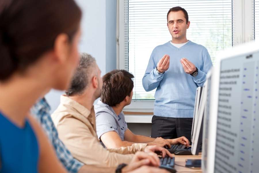 Formateur expliquant un concept à des étudiants lors d’une formation en alternance.
