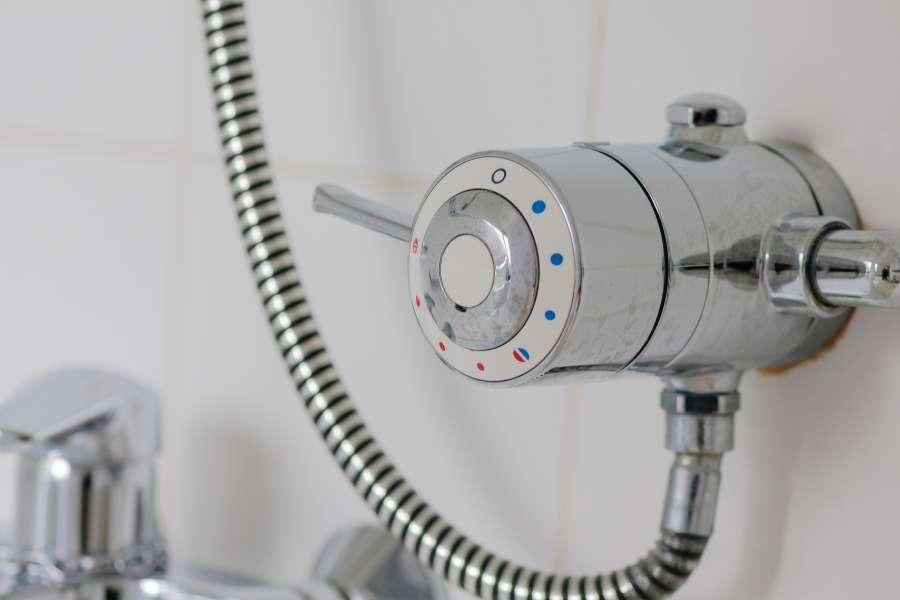 Mitigeur thermostatique chromé pour baignoire. Gros plan sur un mitigeur thermostatique chromé avec réglage de la température.