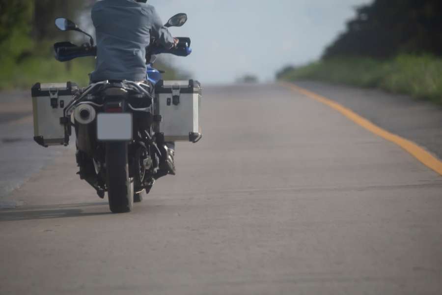 Voyager en moto pour un road trip. Motard roulant sur une route droite et dégagée pendant un road trip à moto.