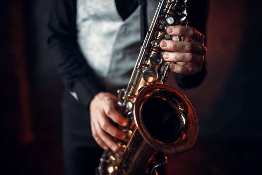 Musicien jouant du saxophone dans une ambiance feutrée illustrant les origines du jazz.