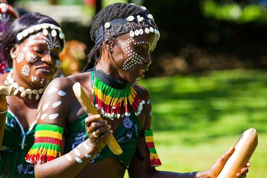Femmes en tenue traditionnelle dansant au rythme des percussions, symbolisant le patrimoine culturel immatériel.