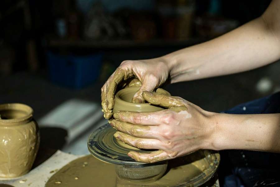 Modelage manuel de l’argile pour la poterie sans tour. Mains d’un potier modelant une pièce en argile selon la technique de poterie sans tour.