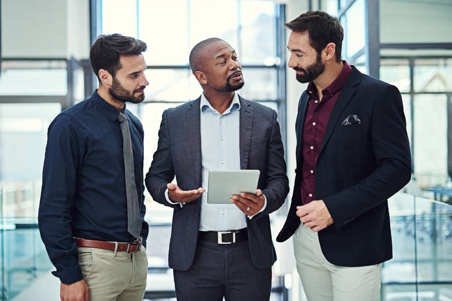 Collaboration et accompagnement dans la reconversion professionnelle. Groupe de professionnels discutant d’un projet lié à la reconversion professionnelle.