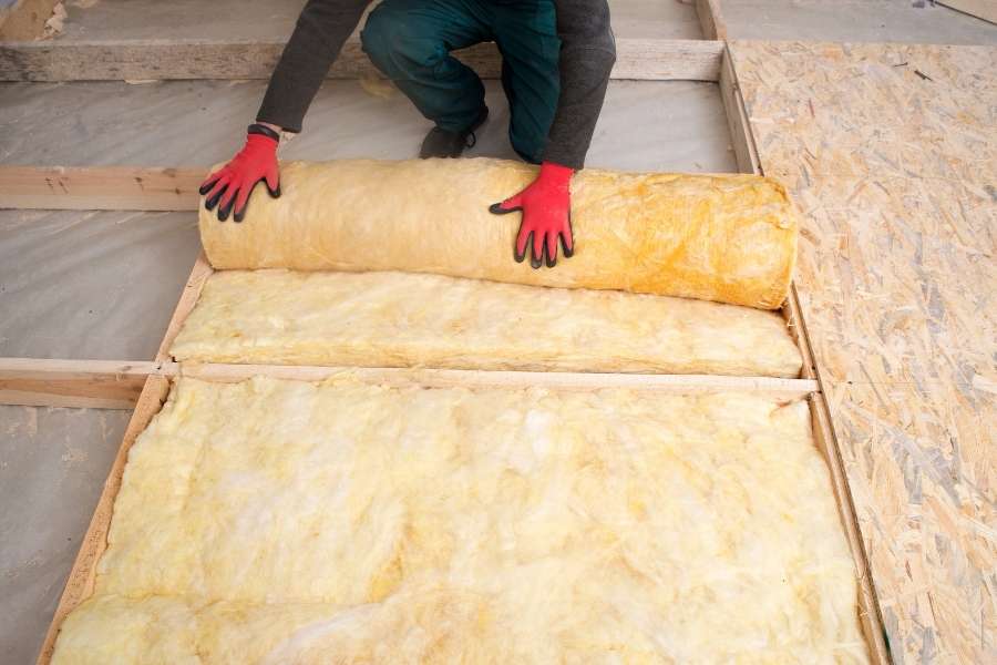 Pose d’une laine isolante pour améliorer l’isolation phonique d’un plancher.
