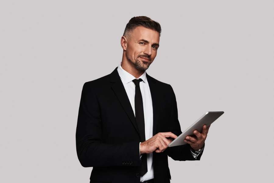 Homme d’affaires utilisant une tablette pour planifier sa reconversion professionnelle.