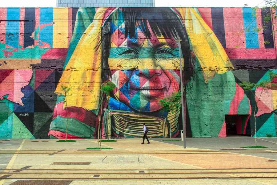 Fresque urbaine inspirée du surréalisme dans l’art contemporain. Fresque murale géante représentant un visage humain multicolore illustrant le surréalisme dans l’art contemporain.