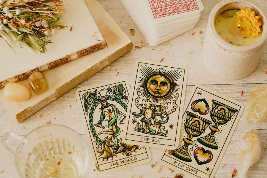 Cartes de tarot colorées disposées sur une table en bois pour un tirage de cartes oracle inspirant.