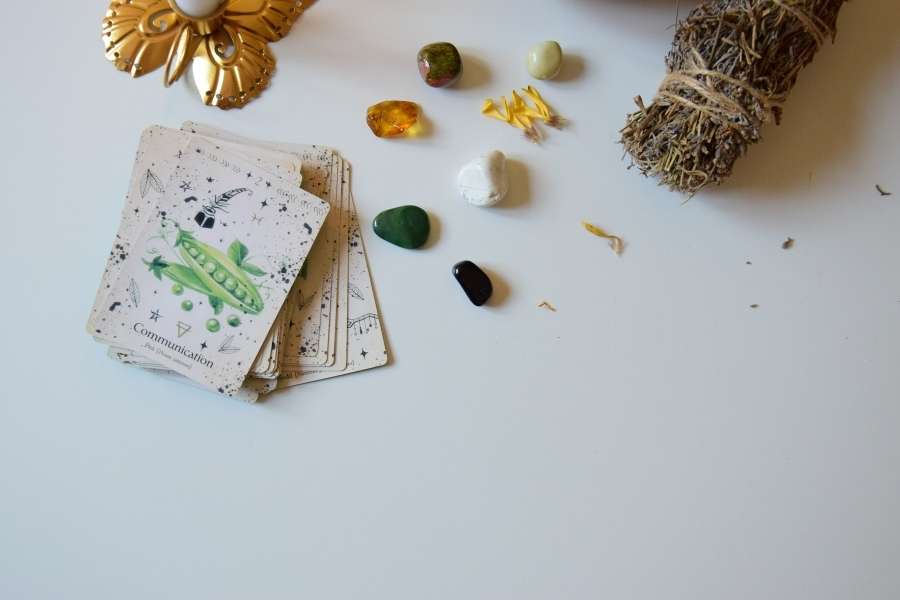Jeu d’oracle et pierres – Tirage de cartes oracle Jeu d’oracle accompagné de pierres énergétiques et d’un bâton de sauge pour un tirage de cartes oracle apaisant.